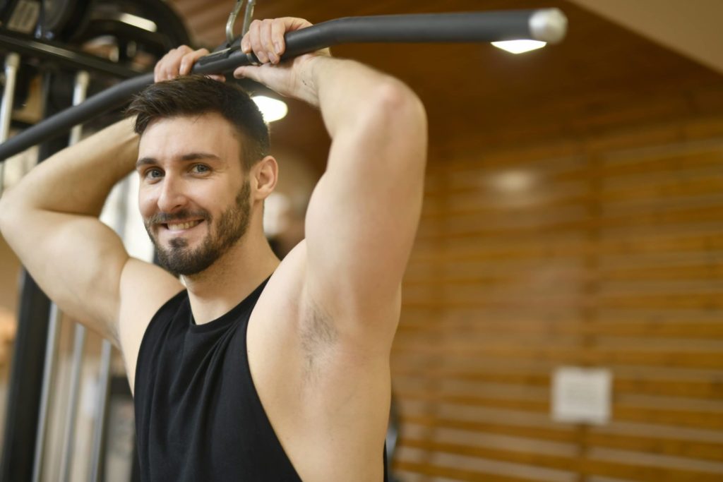 Alain, coach sportif souriant pendant la séance musculation