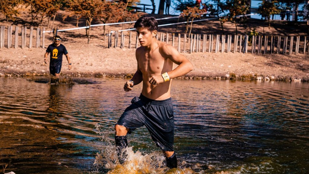 Une jeune athlète avec un short bleu marine courant dans une rivière